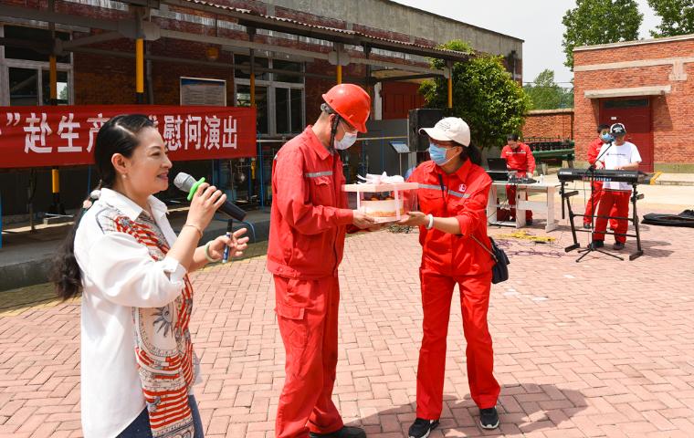 图三:采油工冯海庆(左二)从演员手中接过生日蛋糕,祝您生日快乐的歌声